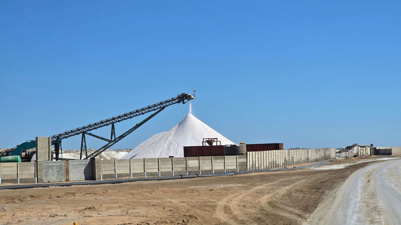 Large salt stockpile and conveyor at a bulk salt yard